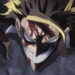 My Hero Academia still: All Might lies prone on shattered asphalt, blood streaking his brow and forearms, yet he flashes a fierce, defiant grin. His blue eyes burn beneath shadowed brows; golden forelocks arc around his face like lightning. Dust flecks and rubble frame a low, skewed close‑up that emphasizes impact and grit.