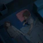 Nighttime anime scene viewed from above: two teens lie on a blue floor beside a low sofa—one girl in a light hoodie and jeans gazing upward, the other (a boy) under a thin gray blanket with a pink pillow, turned toward her as they talk quietly in the dim, cool-toned room. A plant, trash bin, and low TV stand sit nearby in shadow.s
